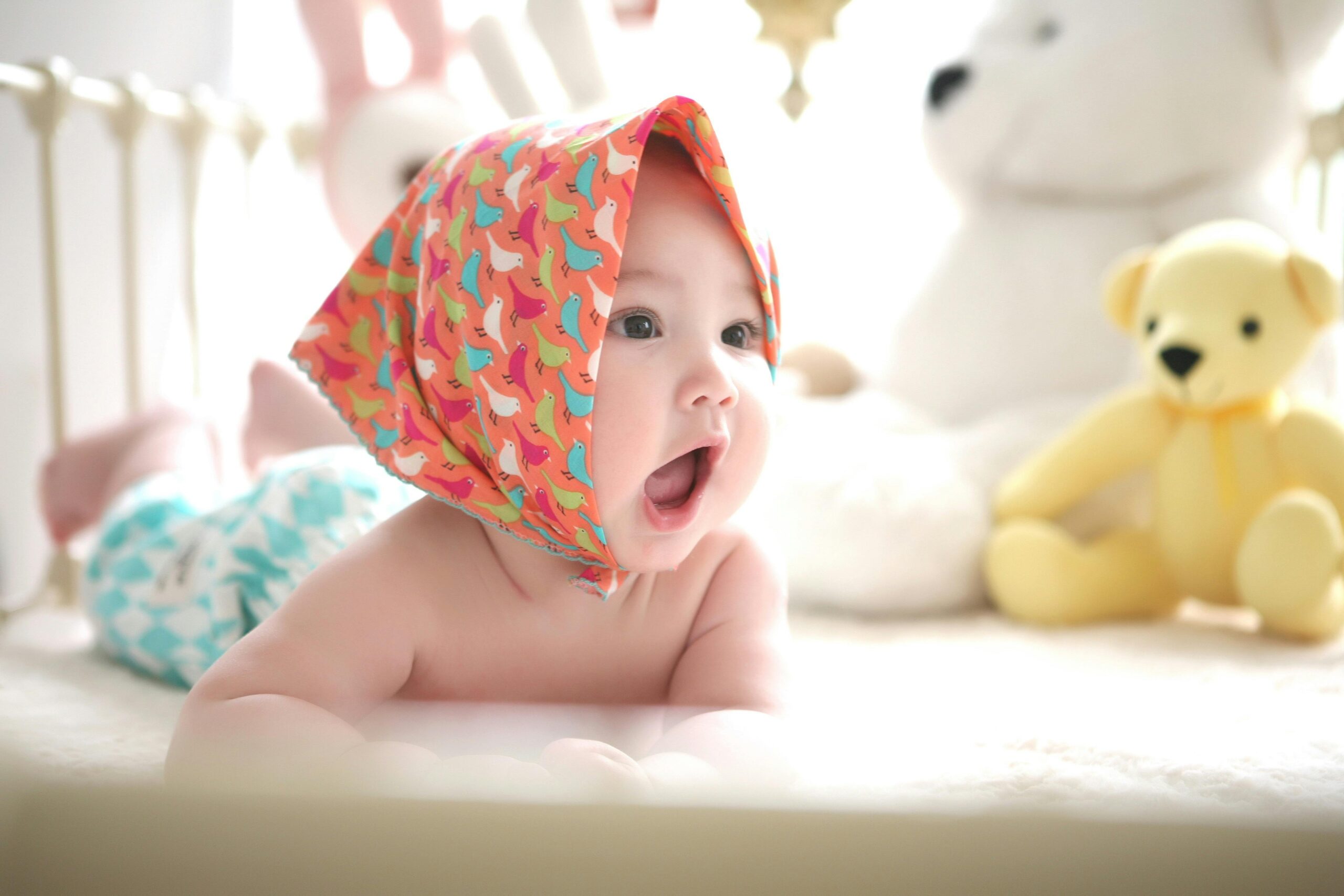 A baby wearing a hat peacefully resting in a crib, surrounded by soft bedding and a serene atmosphere.