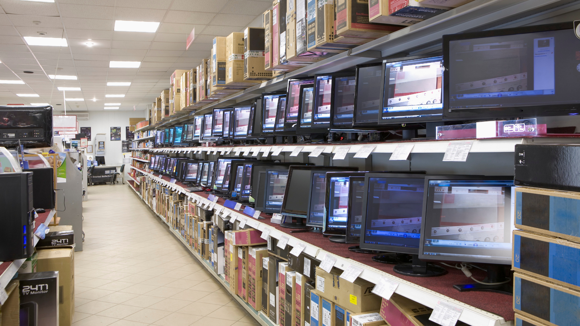 A row of computer monitors displaying various screens in a modern office setting.